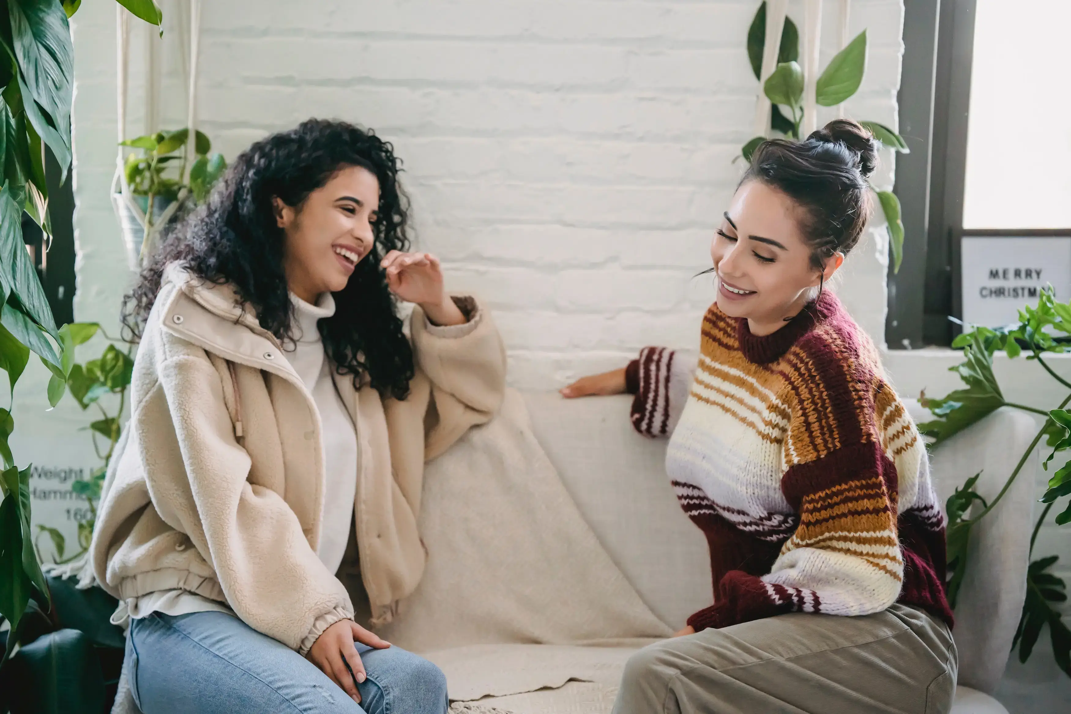 Two women chatting on a couch.